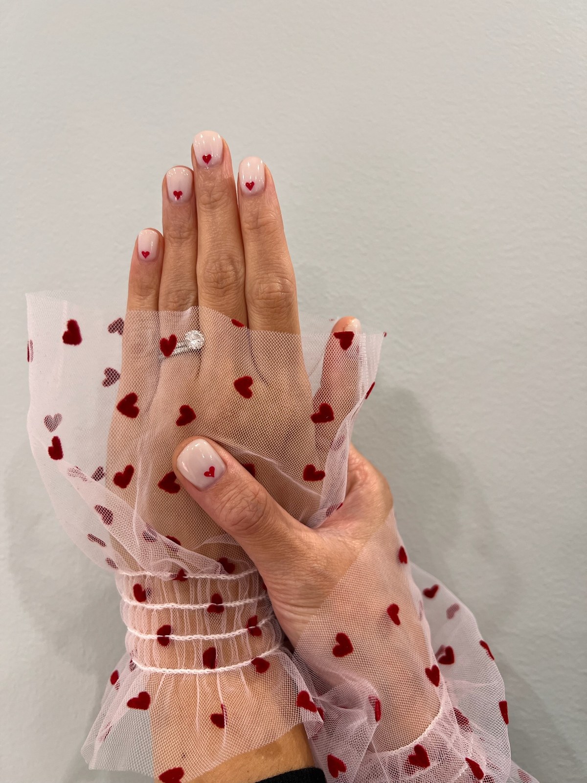 Nude glossy manicure, Valentine's-themed styling shot
