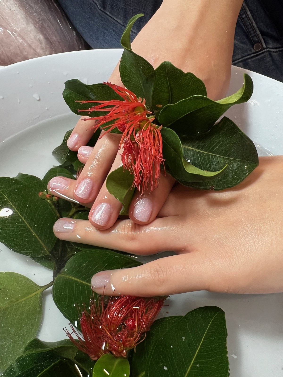Nude glossy manicure styled with a red flower