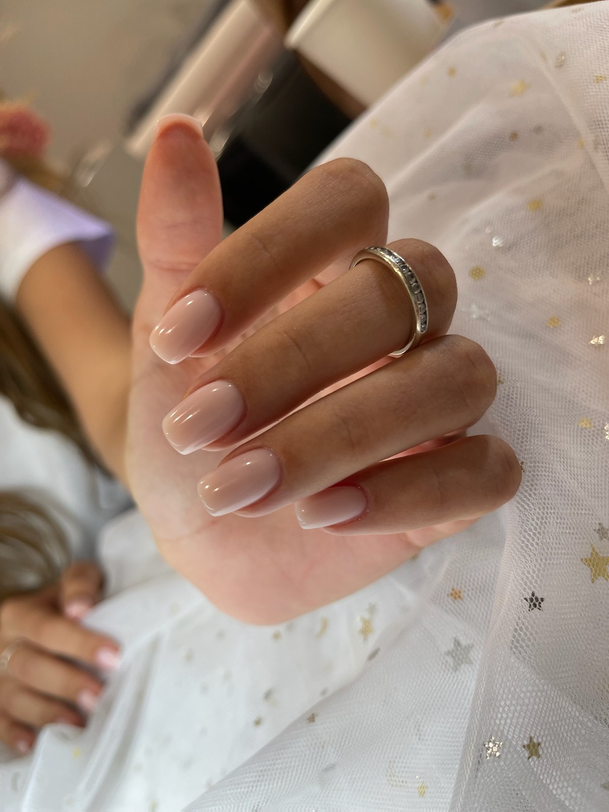 Nude glossy manicure styled with starry tulle