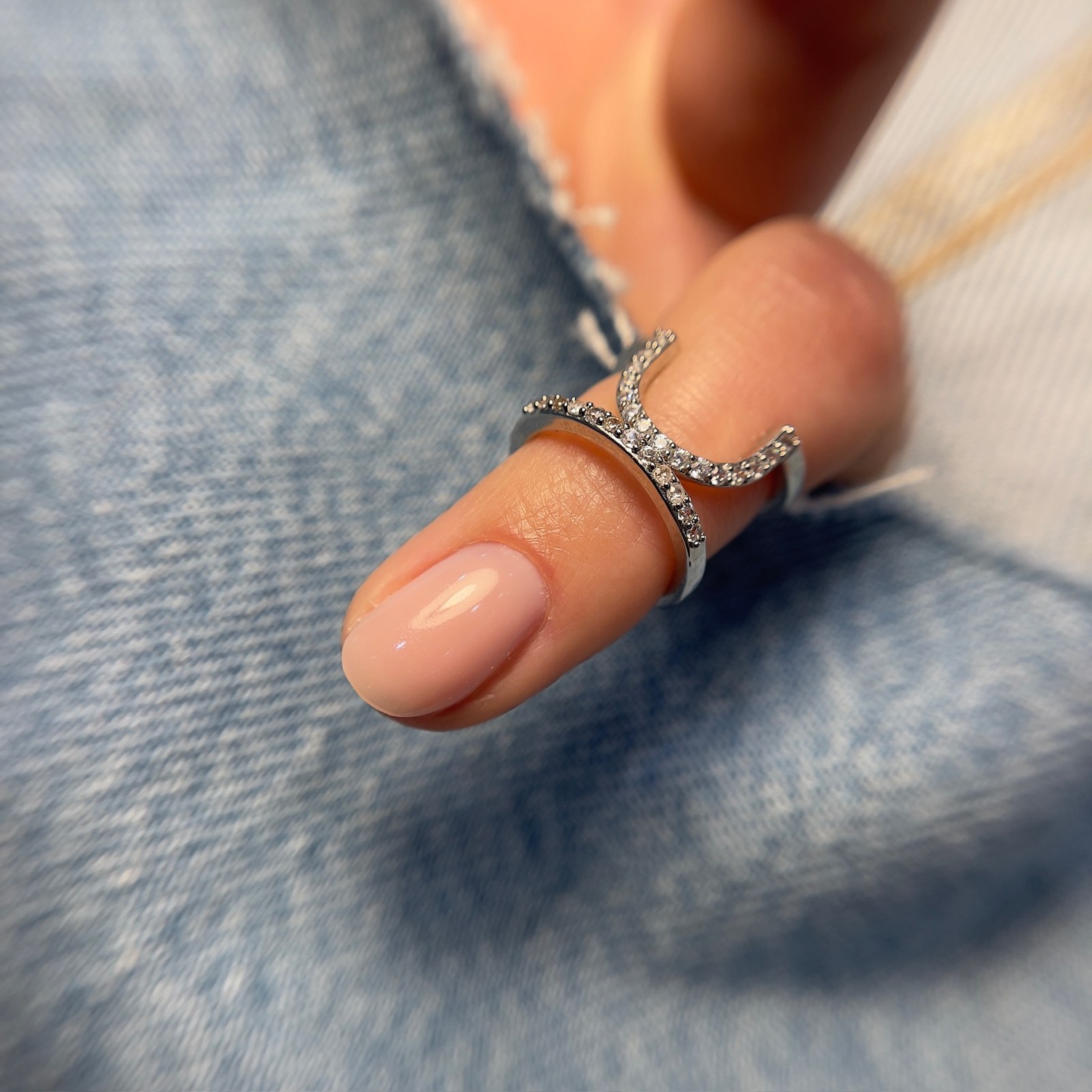 Nude gel manicure close-up with ring detail