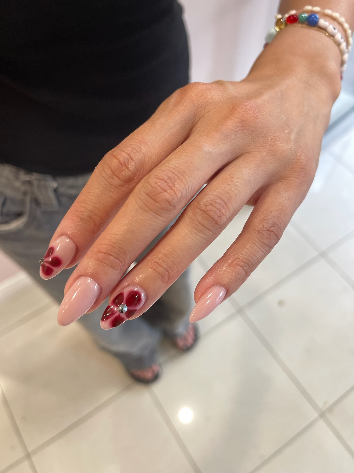 Nude manicure with tiny red heart nail art accents