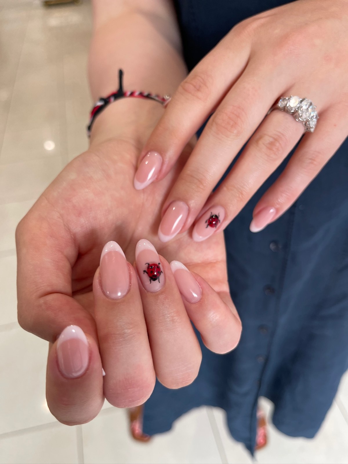 Nude manicure with red heart nail art detail