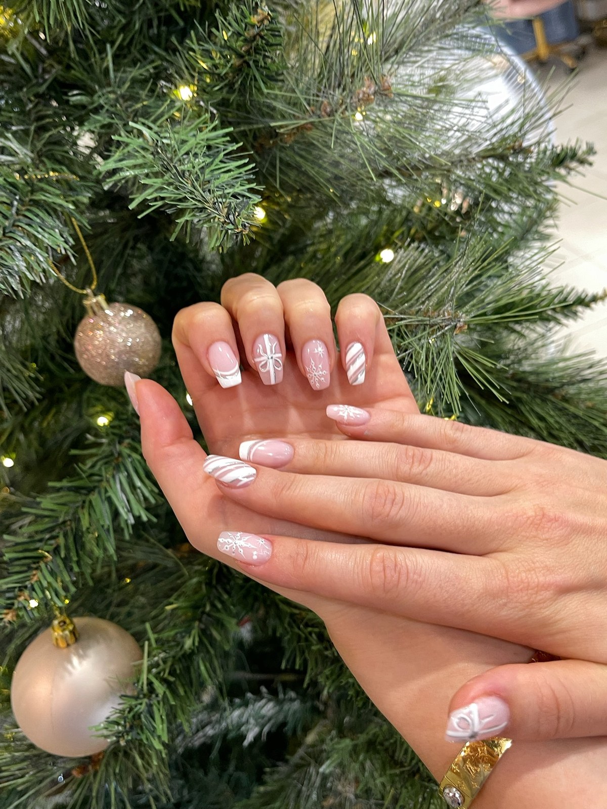 White marbled nail art styled with holiday greenery