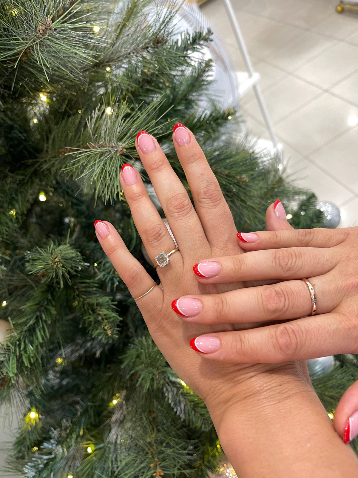 Pink manicure with red heart accent nail styled with holiday greenery