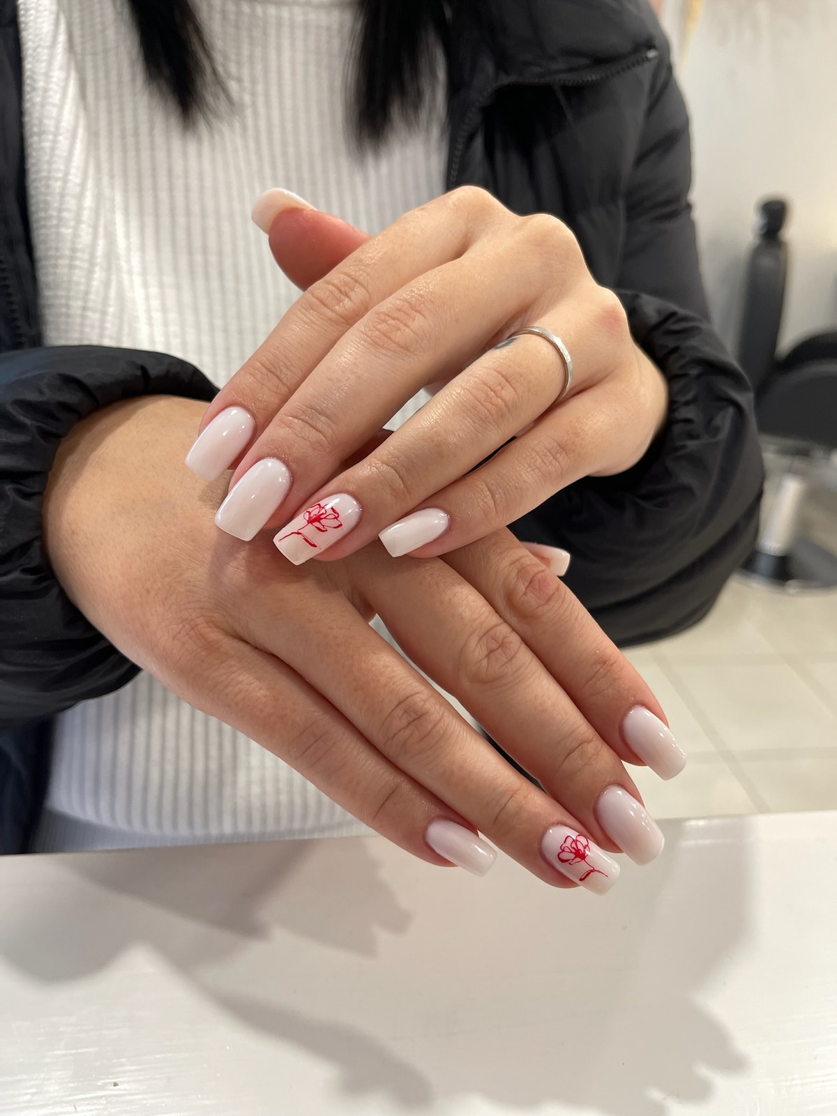 White nail art with red heart accent