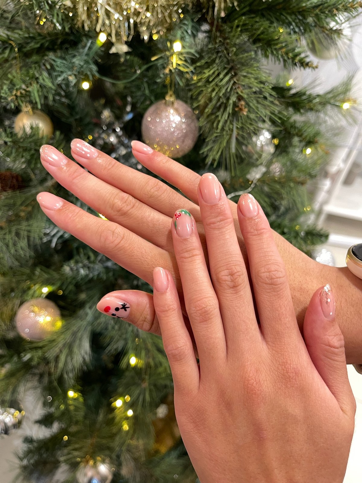 Nude manicure with nail art accent styled with holiday greenery