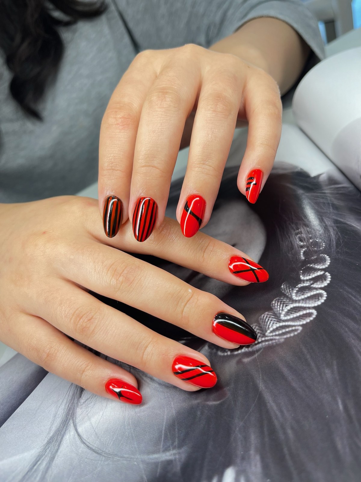 Bold red and black graphic line nail art