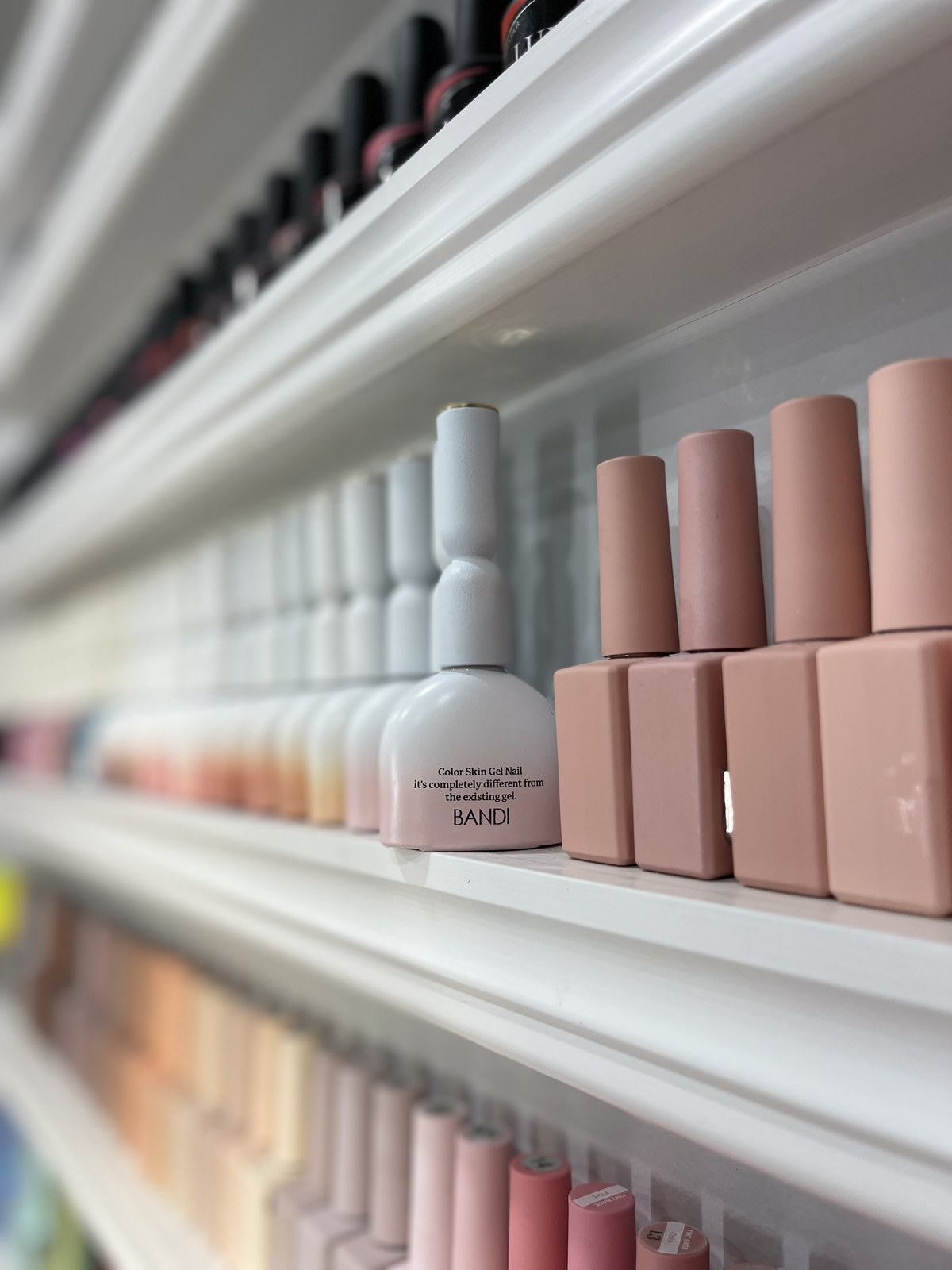 Shelf of nude-tone gel polish bottles