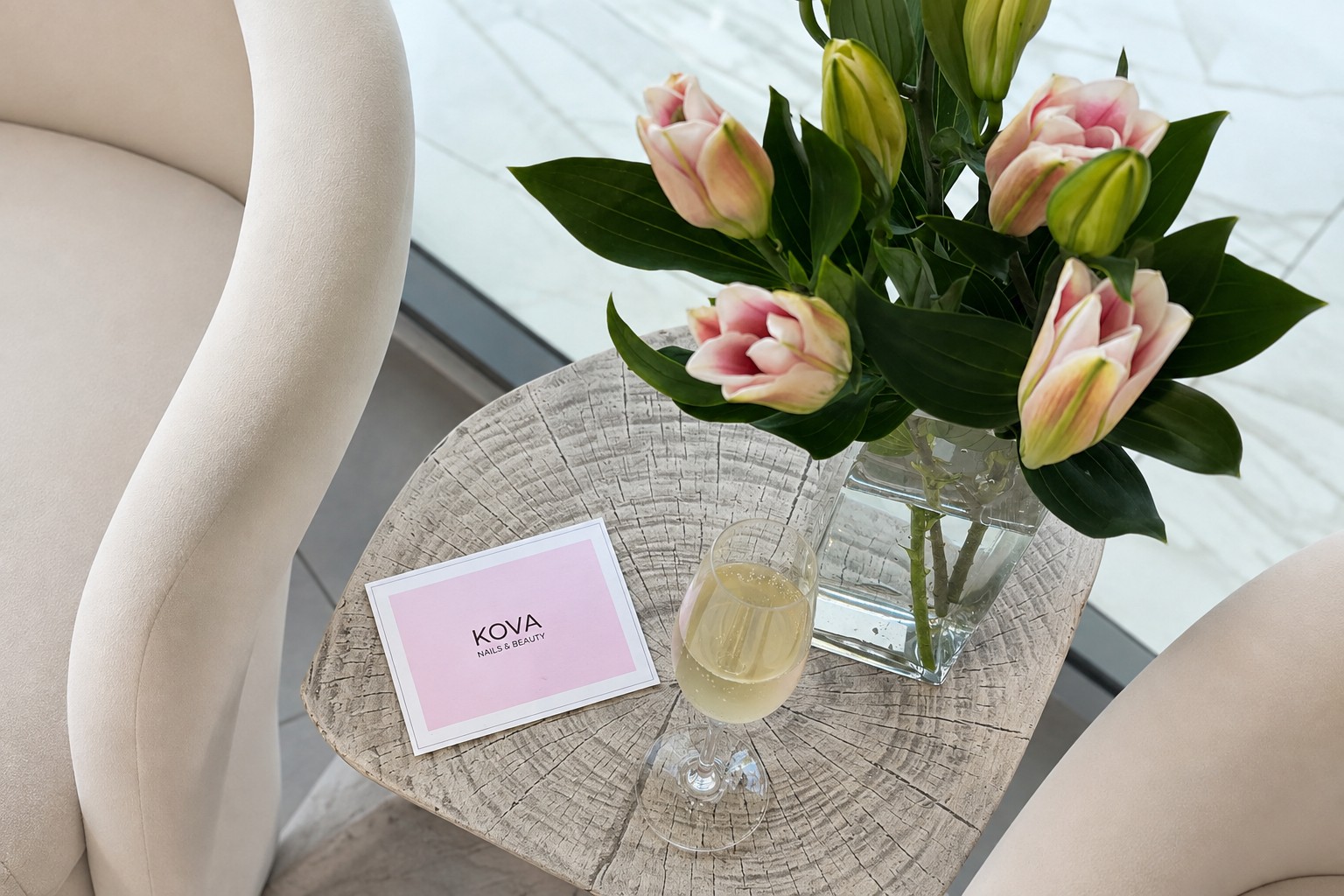 A printed KOVA Nails & Beauty gift card styled with flowers and champagne